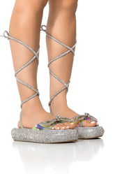 OUTSHINE EMBELLISHED BOW LACE UP FLAT SANDAL IN HOLO